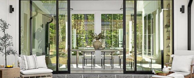 custom open concept living room space that features large glass doors bringing the outdoor and indoor space together