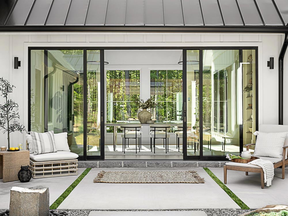custom open concept living room space that features large glass doors bringing the outdoor and indoor space together
