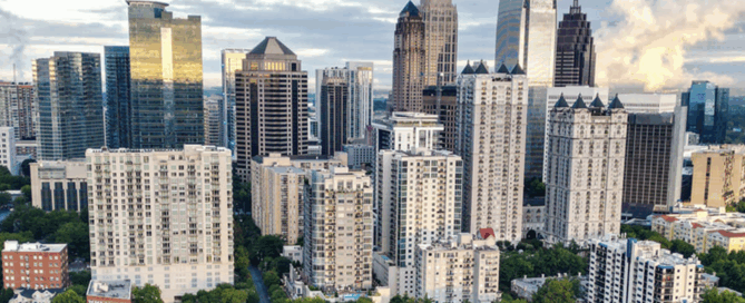 Fulton County downtown cityscape with high-rise buildings, streets, and urban infrastructure under a partly cloudy sky.