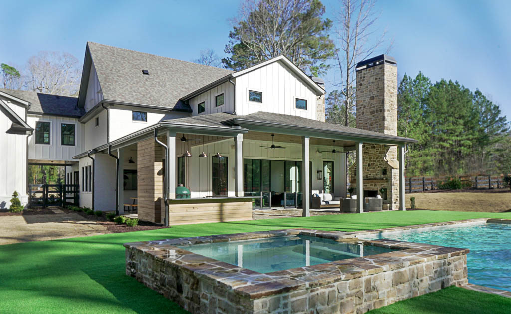 Ecraft Homes Exterior Design Back exterior of a custom home built by Ecraft, featuring covered back patio and pool/spa